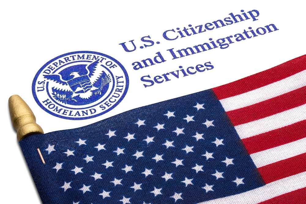 Bandeira dos Estados Unidos com a logo do departamento de imigração dos EUA em cima