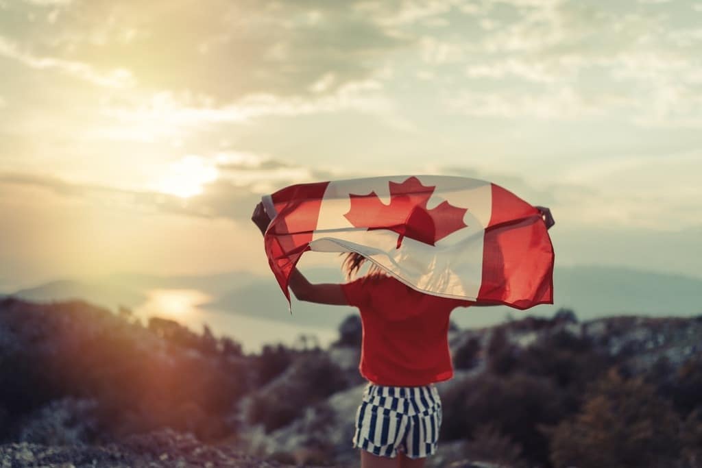 Pessoa com a bandeira do Canadá nas costas representando como morar no canada